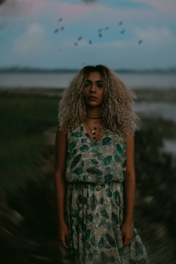 Black woman stands faces camera during dusk. She experienced sexual trauma and gets trauma treatment in cincinnati, oh with Emma Schmidt and Associates 