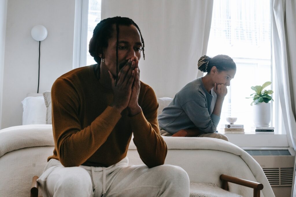 man and wife sit in their room looking depressed as a result of desire discrepancy and mismatched libido. They work with a sex therapist and get sex therapy in Cincinnati, OH at Emma Schmidt and Associates