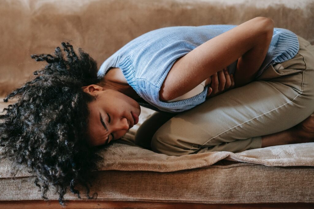 Woman appears to be keeled over in pain. This could represents the pain some women feel during sex also known as vaginismus. Painful sex treatment in Cincinnati, OH can offer support in overcoming this pain. Learn more about painful intercourse treatment in Kentucky, painful intercourse treatment in Indiana, and other services!