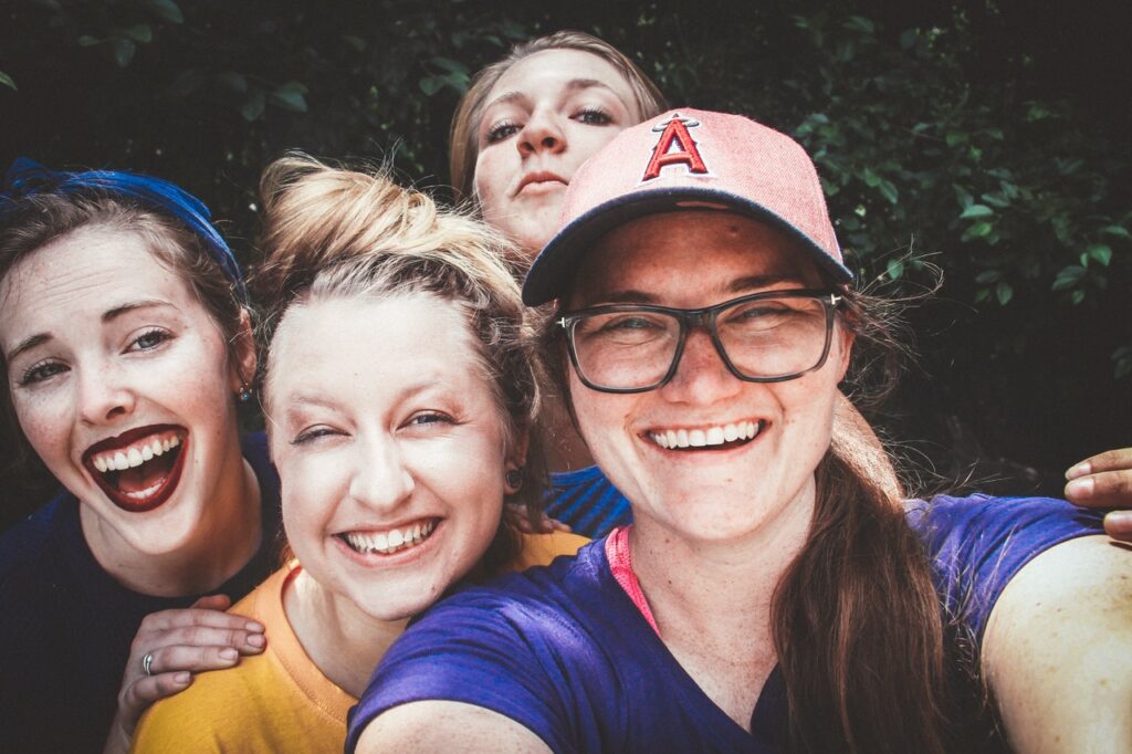 photo of a group of happy teen girls smiling at the camera representing the joy you can feel after teen therapy in cincinnati, OH