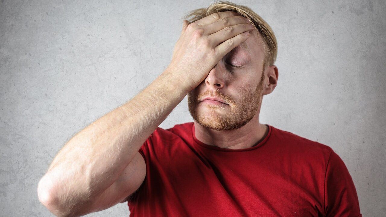 A man facepalms as he appears annoyed about something on his mind. This could represent the anxiety of sexual dysfunction. Contact a sex therapist in ohio, or search "couples sex therapist near me" for more support. Anxiety treatment can offer the help you need!