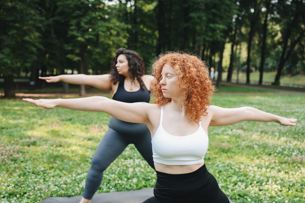 A pair of women practice yoga outside in a field. Yoga therapy in Ft. Mitchell, KY can offer support in-person and online. Learn more about online yoga therapy in Kentucky, by contacting a yoga therapist in Cincinnati, OH with our team today. 45208