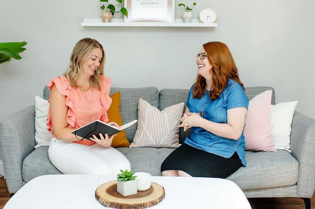 Two therapists with Emma Schmidt & Assoc. smile as they talk to one another. Contact them to learn more about our upcoming relationship workshops in Cincinnati, OH. We offer online relationship workshops in Ohio and more! 45208