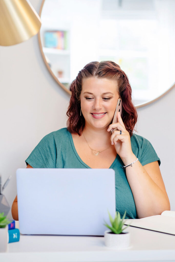 A therapist smiles at her laptop while on the phone with someone. This could represent a depression therapist in Cincinnati, OH preparing for online deperession therapy. Learn more about therapy in Cincinnati, OH and more by contacting an online therapist in Ohio today! 45208