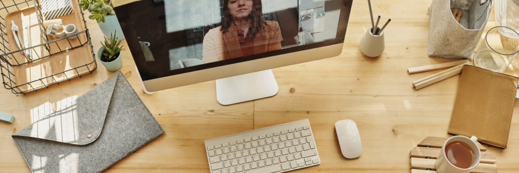 A close up of a computer desk with a person on screen. This could symbolize meeting with an online therapist in Ohio for online depression therapy in Cincinnati, OH. Contact Emma Schmidt to learn more about online therapy in Kentucky and other services today!