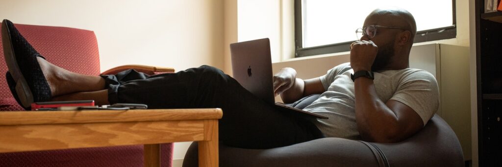 A man relaxes with his feet crossed on a table while typing on their laptop. This could represent the convenience of meeting with an online therapist in Ohio. Contact Emma Schmidt and Assoc. to learn more about online therapy in Ohio, online depression therapy in Cincinnati, OH, and other mental health services.